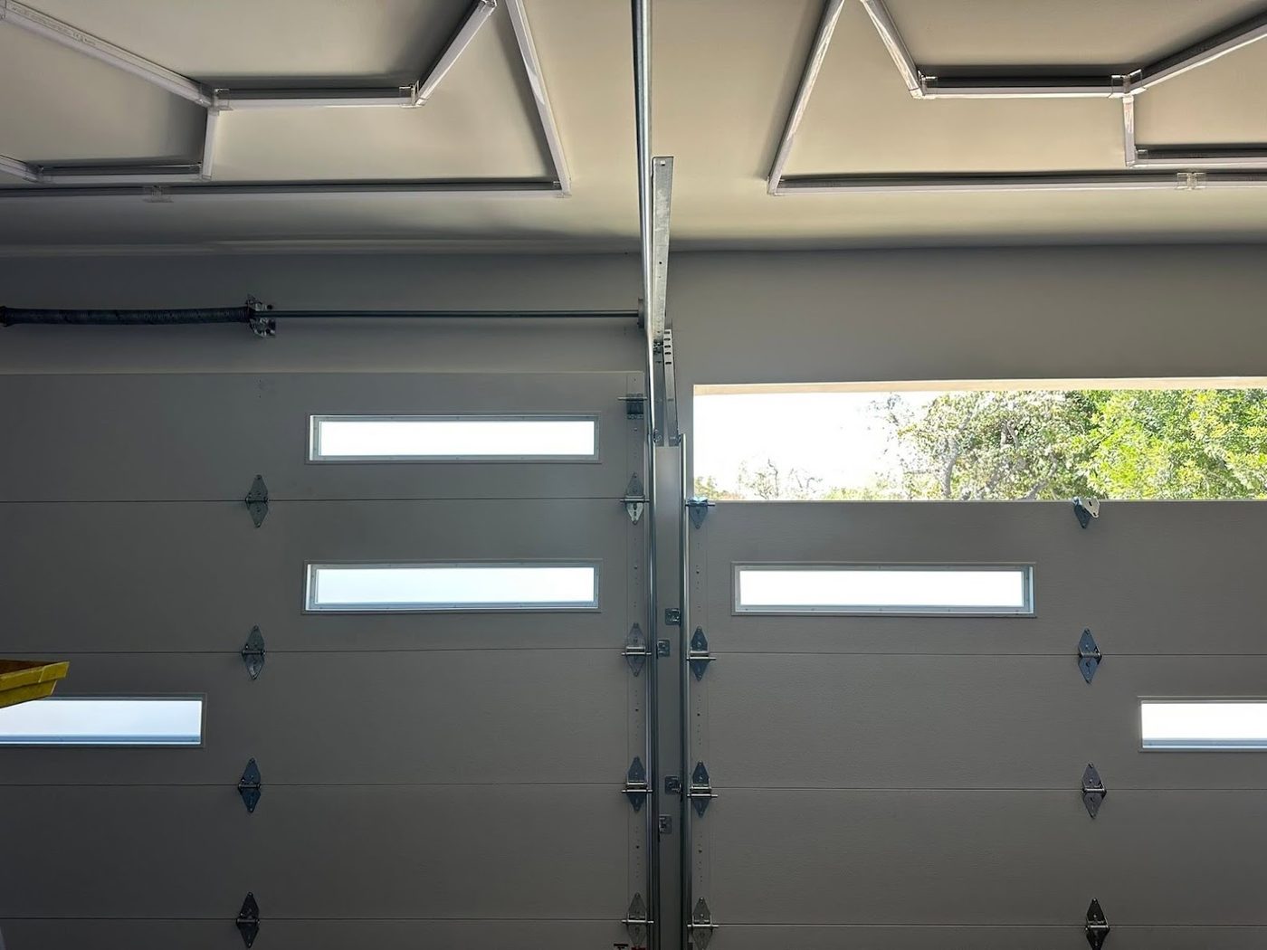 Garage door torsion spring system above the door